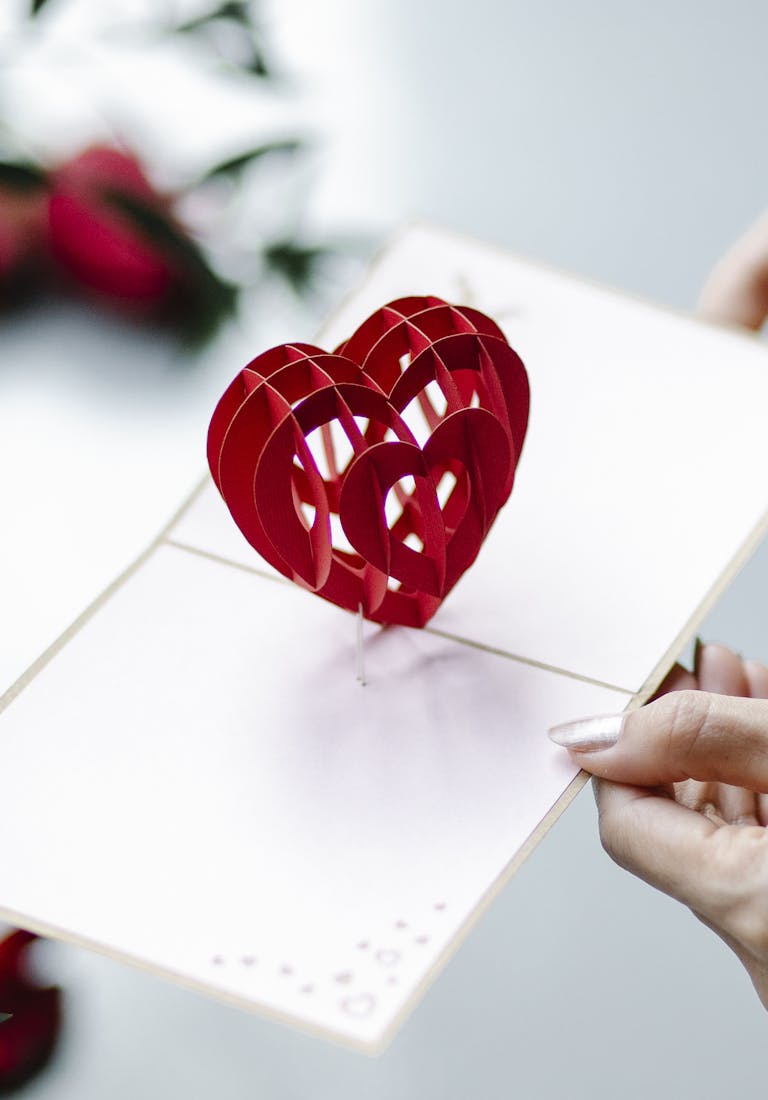 Elegant red heart pop-up card held by a woman, perfect for Valentine's Day celebrations.